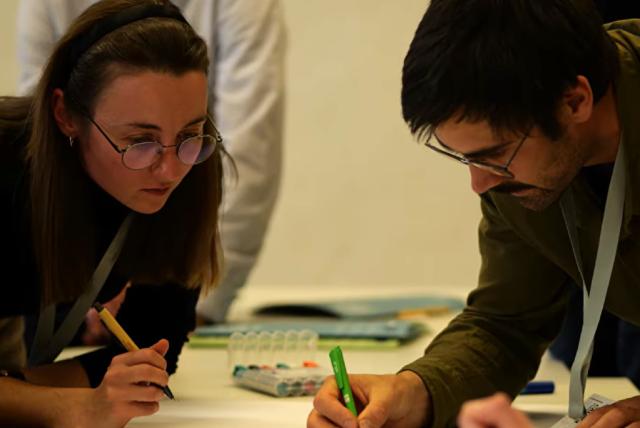 Emberek dolgoznak egy asztal mellett